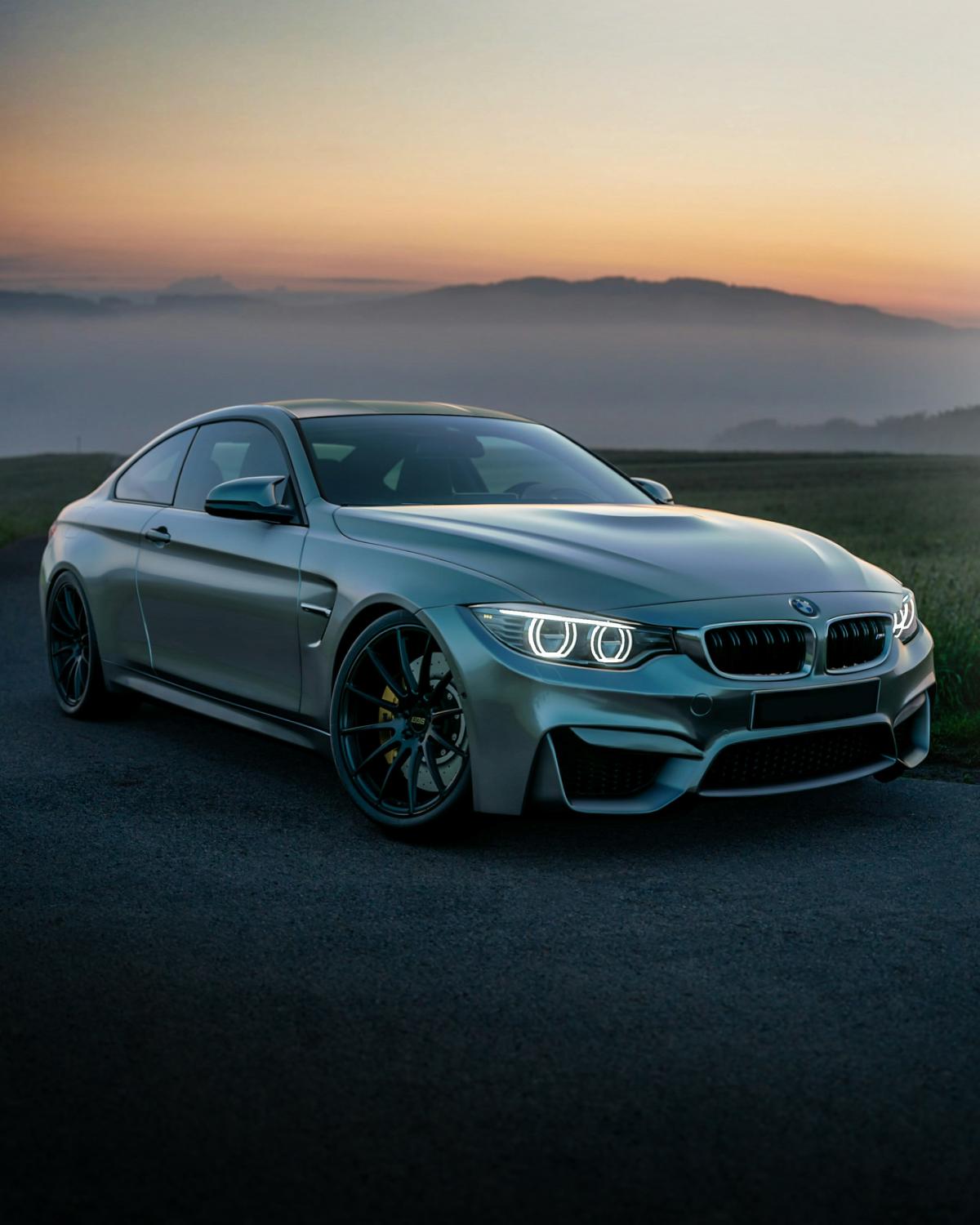 Photo of a BMW with mountains in the distance  - photo by Josh Berquist via Unsplash